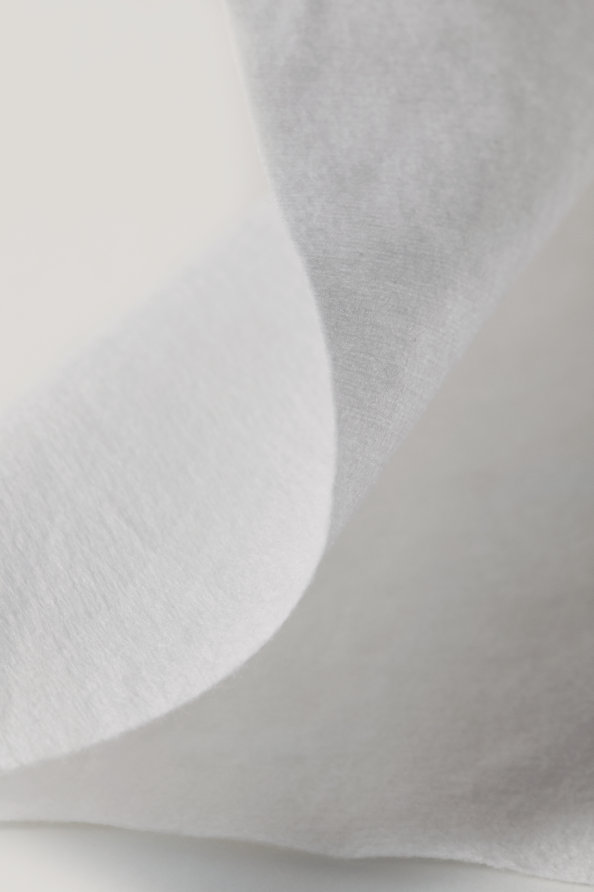 Close-up of a l'Essentiel cotton tissue texture with a light gray background